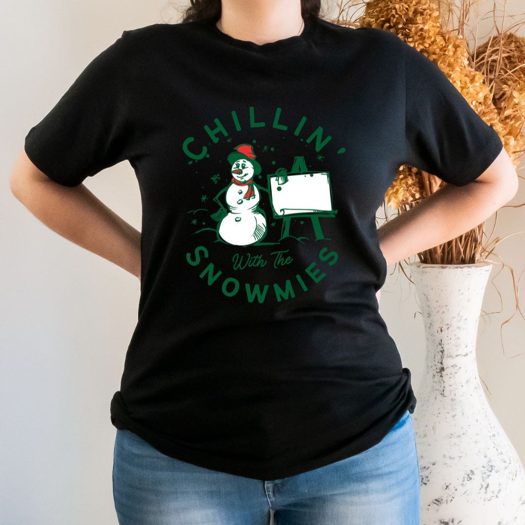 "Chillin' with the snowmies text design centered on black t-shirt."