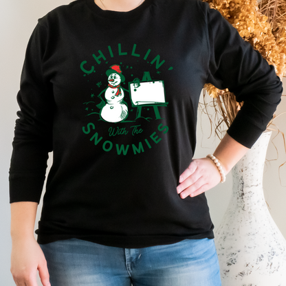 "Chillin' with the snowmies text design centered on black long sleeve shirt."