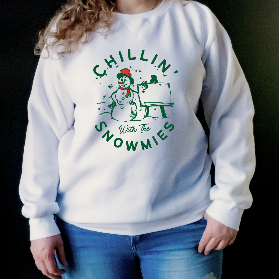 "Chillin' with the snowmies text design centered on white sweater."
