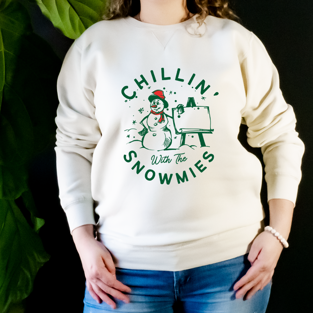 "Chillin' with the snowmies text design centered on natural sweater."