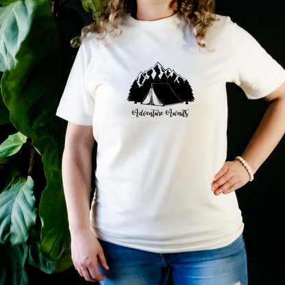 "The shirt features a design of a camping scene; a cozy tent sits in the middle of a forest, surrounded by trees and a mountain range in the distance. We want to capture the adventurous spirit and love for the great outdoors that camping lovers feel".