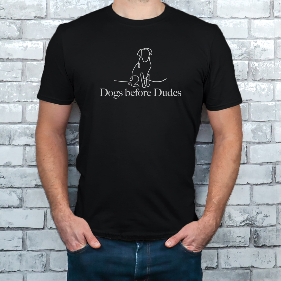 "Dogs before dudes text and graphic design centered on black t-shirt."