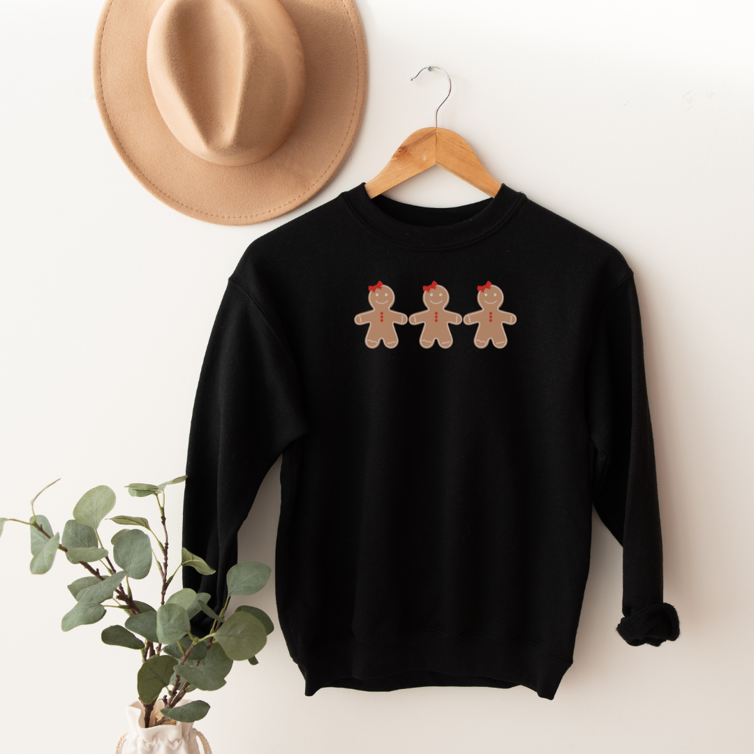 "Gingerbread cookies graphic design centered on black sweater"