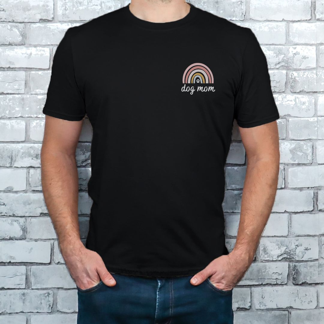 "Dog mom rainbow text and graphic design left pocket position on black t-shirt."
