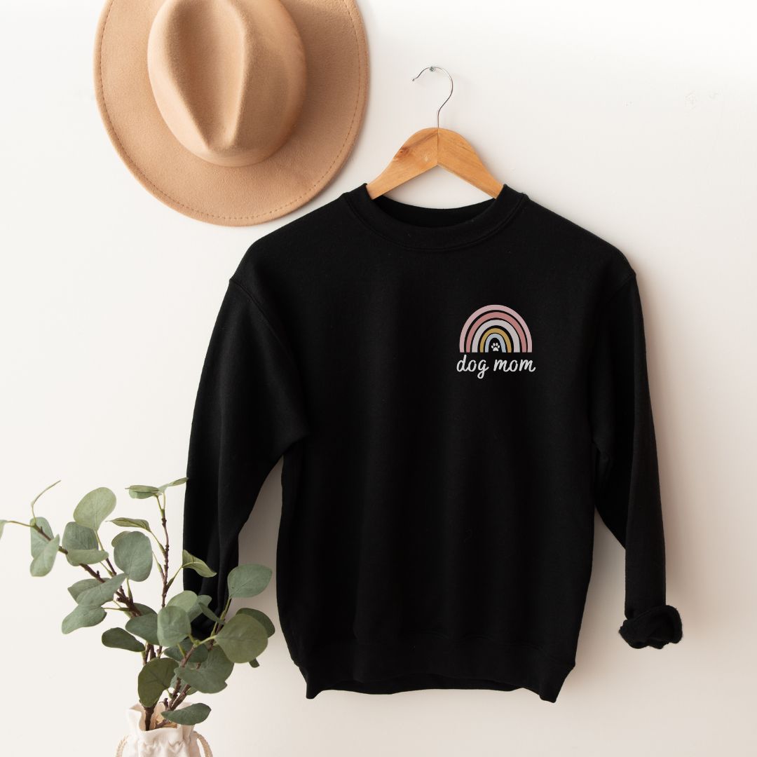 "Dog mom rainbow text and graphic design left pocket position on black sweater."