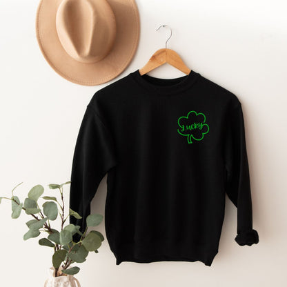 "Lucky Clover graphic design centered on black sweater."